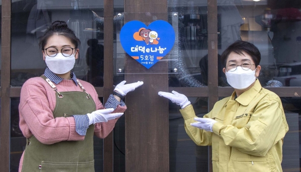 박정현 대덕구청장이 신탄진동 ‘커피를福堂’에서 대덕e나눔 5호점 지정 현판을 부착하고 있다
