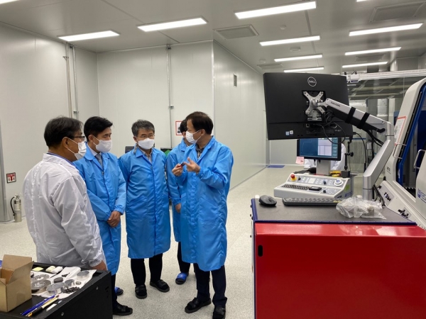 최병욱 총장과 학무위원들이 대덕산학융합캠퍼스 스마트광학혁신단의 초정밀 가공지원실을 둘러보고 가공시연 설명을 듣고 있다.