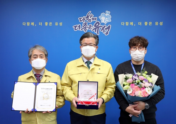 지난 20일 구청 행복사랑방에서 정용래 유성구청장(가운데)이 조상화 홍보실장(왼쪽), 홍성후 주무관(오른쪽)과 함께 2020 대한민국 SNS 대상 최우수상 수상 표창패를 들고 기념촬영을 하고 있다.