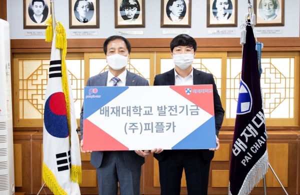 김선재(왼쪽) 배재대 총장이 26일 강석현 ㈜피플카 대표이사에게 지역인재 육성 발전기금 1000만원을 전달받고 있다