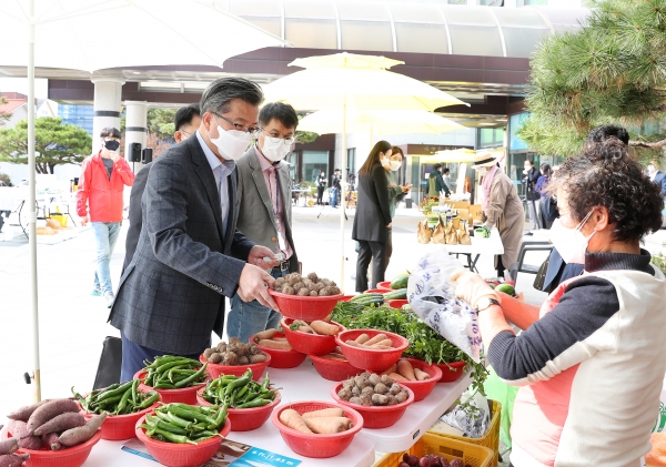 29일 오전 구청 광장에서 로컬푸드 생산농가의 판매 활성화를 위한 행복팜 프리마켓이 열리고 있는 가운데 정용래 유성구청장이 지역 농가에서 생산한 농산물을 구매하고 있다
