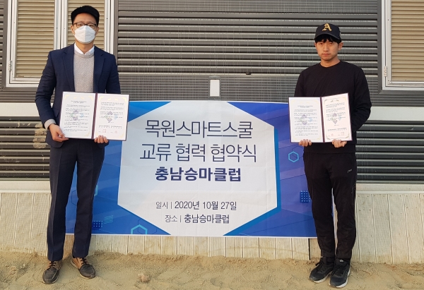 지난달 27일 충남 논산시 은진면 충남승마클럽에서 이승준 목원스마트스쿨 사무국장(왼쪽)이 이영진 충남승마클럽 대표와 승마교실 운영 관련 협약을 체결하고 기념촬영을 하고 있다.