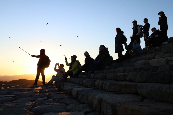계족산성에 도착한 참가자들이 주변 풍광에 대한 설명을 듣고 있다