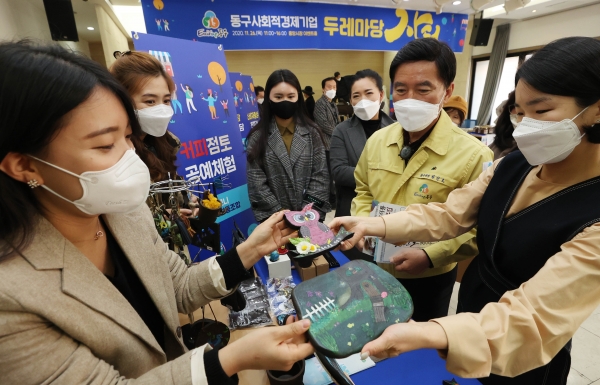 황인호 동구청장(오른쪽)이 사회적경제 기업 물품 보는 모습