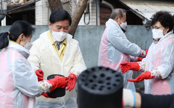 황인호 동구청장(왼쪽 두번째)이 통장협의회와 연탄을 나르는 모습