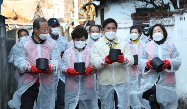 황인호 동구청장(가운데)이 통장협의회와 연탄 나르는 모습