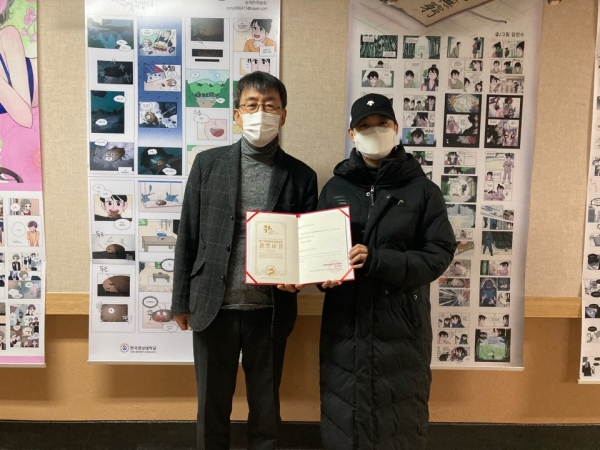 중국 금룡상을 수상한 장주홍 학생이 상장을 들고 기념사진을 찍고 있다.