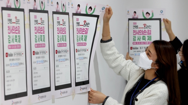 동구청 직원들이 홍보 포스터를 붙이고 있다.