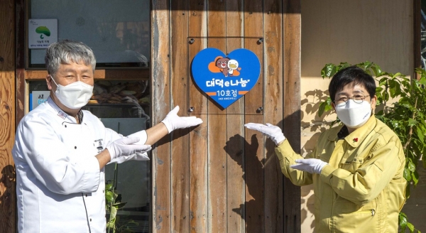 박정현 대덕구청장이 비래동 ‘에코브레드하우스’빵집에 대덕e나눔 10호점 지정 현판을 부착하고 있다.