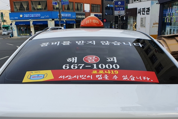 택시 뒷유리에 코로나19 사회적 거리두기 동참 표어 홍보물 부착 사진