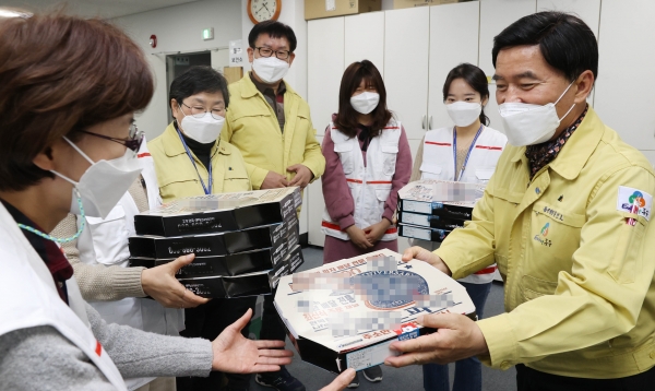 황인호 동구청장(오른쪽)이 보건소 직원들에게 피자를 건네며 격려하는 모습