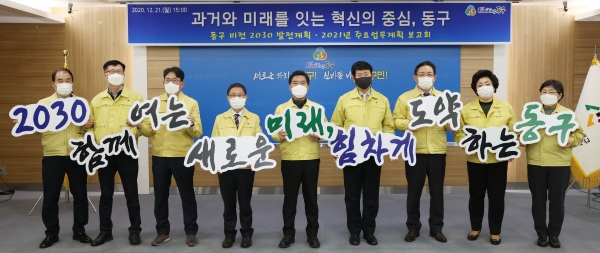 황인호 동구청장(사진 가운데)과 간부 공무원들이 발전 메시지를 담은 손 피켓을 들고 기념촬영을 하고 있다.