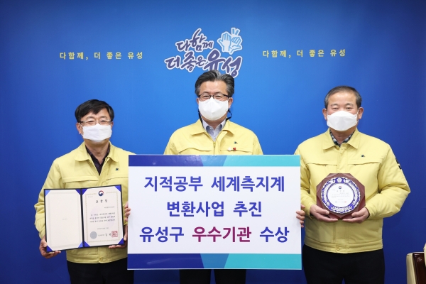 지난 28일 구청 행복사랑방에서 정용래 유성구청장(가운데)이 이하경 행정지원국장(오른쪽), 이몽용 토지정보과장(왼쪽)과 함께 지적공부 세계측지계변환 우수기관 표창장을 들고 기념촬영