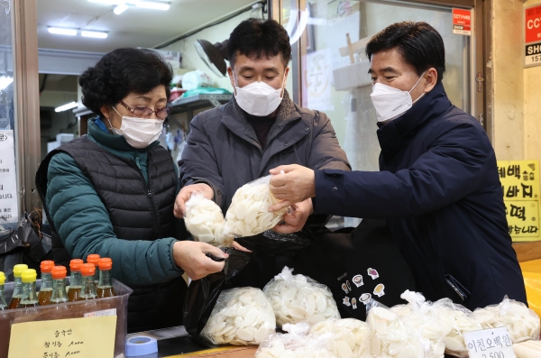 황인호 동구청장(오른쪽)이 중앙시장에 위치한 상가에서 물건을 구매하는 모습