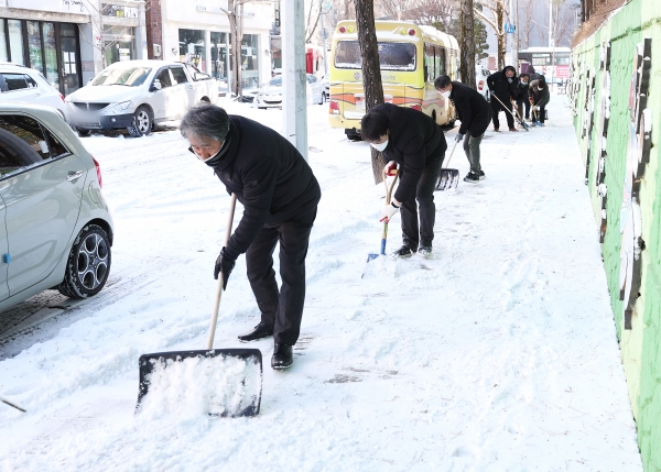 7일 오전 유성구청 직원들이 대전공업고등학교 주변 인도에 쌓인 눈을 치우고 있다