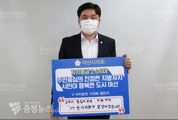 아산시의회 황재만 의장이 18일‘자치분권 2.0시대의 개막을 응원하는 메시지 팻말을 들고 34만 아산시민과 새로운 미래를 이뤄내겠다’라며 각오를 밝히고 있다.
