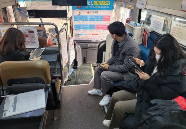 21일 천안시 서북구 소재 SKL모바일 사옥 앞에서 진행된 ‘코로나19극복, 2021 사랑의 헌혈행사’에 참석한 임직원들이 헌혈 전 문진표를 작성하고 있다.