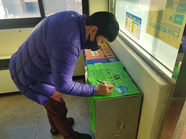 대덕구청 소속 직원이 종량제봉투 부서실명제 스티커에 부서명을 기재하고 있다.