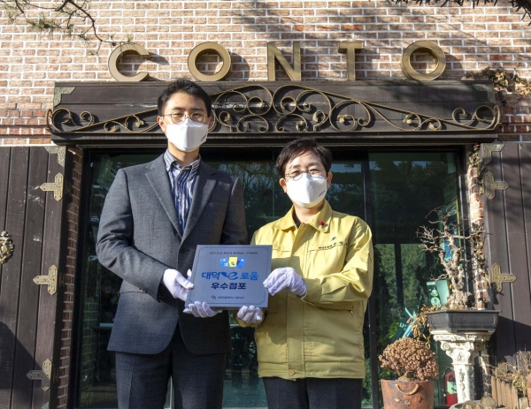 박정현 대덕구청장이 지난 25일 회덕동 계족산 자락에 위치한 ‘꽁뚜’레스토랑에 대덕e로움 우수점포 지정 현판을 부착했다