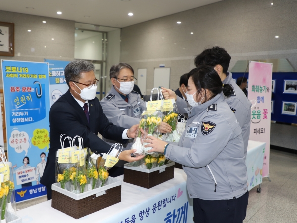 길정섭 본부장(왼쪽), 충청남도경찰청 김홍근 공공안전부장(오른쪽)이 출근길 충남경찰청 직원들에게 사랑의 프리지아 꽃 화병을 나누어 주고 있다.