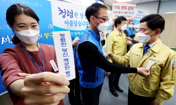 황인호 동구청장이 박종옥 동구 노조위원장에게 서로 리본을 달아 주고 있다.