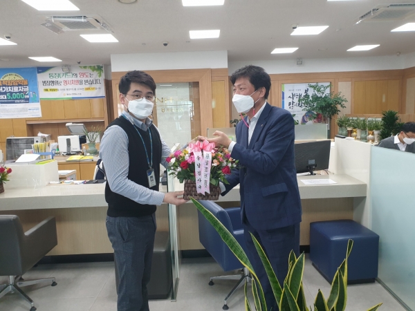 농협충남검사국 김용철 국장(오른쪽)이 종합감사기간 중 계룡농협 직원에게 꽃바구니를 전달하고 있다.