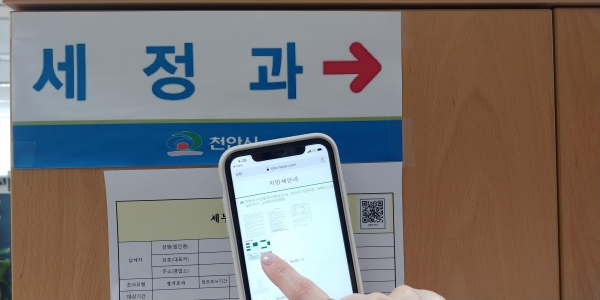 관계자가 QR코드 활용해 지방세 정보를 스마트폰으로 확인하는 모습