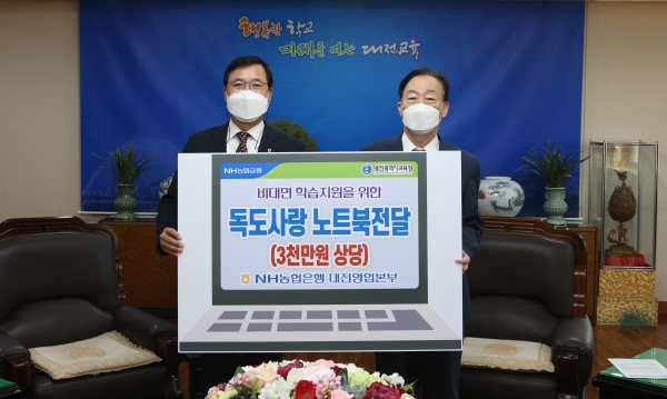 NH농협은행 대전영업본부 임직원들이 노트북을 전달하며, 기념촬영을 하고 있다.(왼쪽에서 두 번째가 NH농협은행 대전영업본부장 김동수)