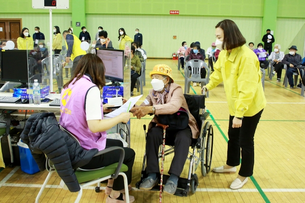 접종 전 신분증 확인 및 접수를 돕는 장면