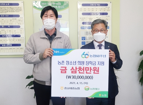 길정섭 충남세종농협 본부장(오른쪽)이 충남세종지역을 대표하여 김준호 장곡농협 조합장(왼쪽)에게 농촌지역 다문화가정 청소년 희망 장학금 3천만원을 전달하고 있다.