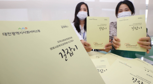 동구청 관계자가 가이드북과 함께 포즈를 취하고 있다