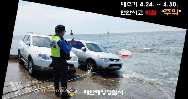 대조기(사리기간) 해양경찰이 밀물 침수차량에 유실방지 밧줄을 설치하고 차주에게 연락을 쥐하고 있다. /출처=태안해양경찰서