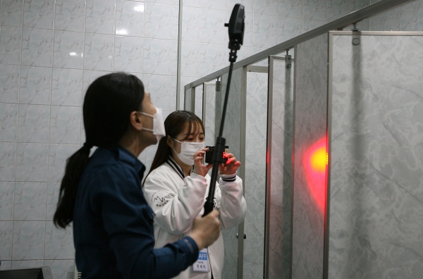 중앙도서관 1층 여자화장실에서 경찰과 총학생회 관계자가 불법촬영 카메라 탐지 장비로 화장실을 점검하고 있다.