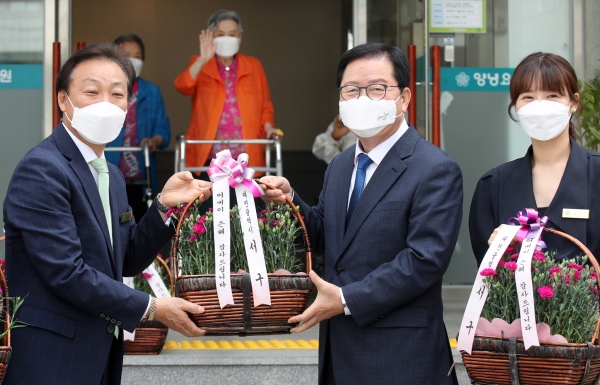 어버이날을 앞두고 장종태 대전 서구청장이 양녕요양원을 방문하여 관계자를 통해 카네이션을 전달하고 있다.