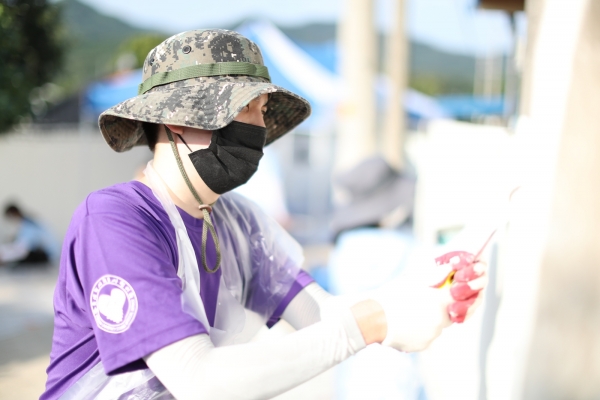 농촌재능나눔에 참여한 대학생이 마을환경개선을 위한 외벽 페인트 작업을 하고 있다.