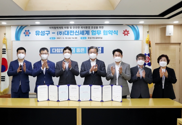 12일 구청 중회의실에서 정용래 유성구청장(왼쪽에서 네 번째)이 ㈜대전신세계와 지역협력계획 이행 및 안전한 외식환경 조성을 위한 업무협약을 맺고 있다