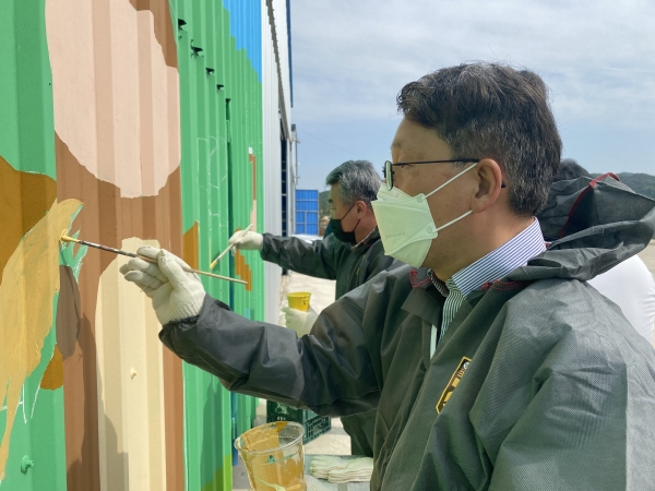 송현승 충남세종농협 부본부장(앞)과 정만교 부여축협 조합장(뒤)이 축산환경 개선의 날을 맞아 부여군 남면 호암농장에서 예쁜 벽화 그리기 봉사활동을 벌이고 있다.