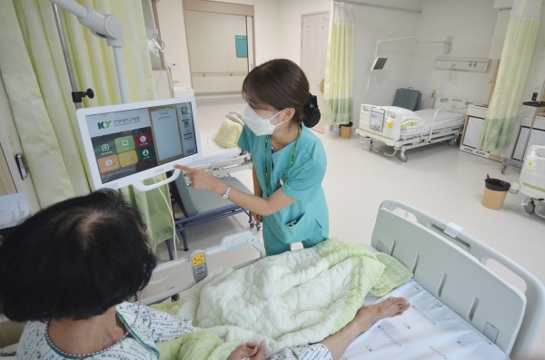 건양대병원 간호사가 4인실에 입원한 환자에게 배드사이드 모니터 사용법을 설명하는 모습