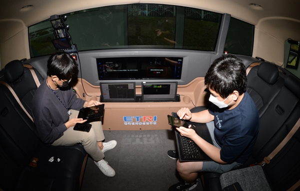 ETRI 연구진이 개발한 자율주행 셔틀버스 '오토비' 에서 운전에 신경쓰지 않고 다른 콘텐츠를 즐기고 있는 모습