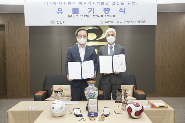 지난 13일 시청 소회의실에서 가칭 대한민국 축구역사박물관 건립을 위한 유물기증식을 개최해 박상돈 천안시장(왼쪽)과 박경훈 전무이사(오른쪽)가 기증품과 유물 기증서를 들고 기념사진