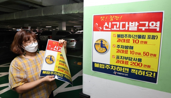 동구청 직원들이 스티커를 붙이고 있다.