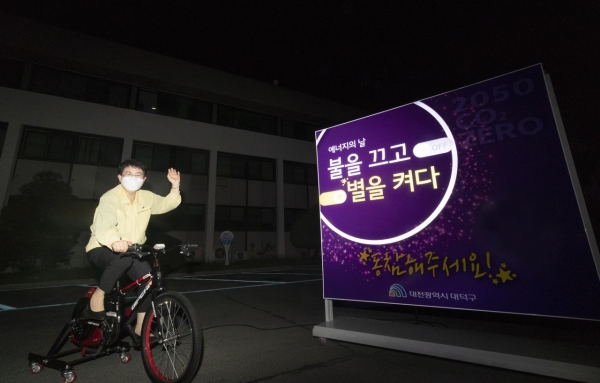 박정현 대덕구청장이 발전 자전거를 구르며 ‘불을 끄고 별을 켜다’레터링 점등 이벤트에 참여하고 있다