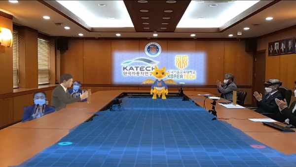 회의실 한쪽에 한국자동차연구원의 참석자가 3D 아바타와 홀로그램으로 등장하여 협약식을 진행하고 있다.