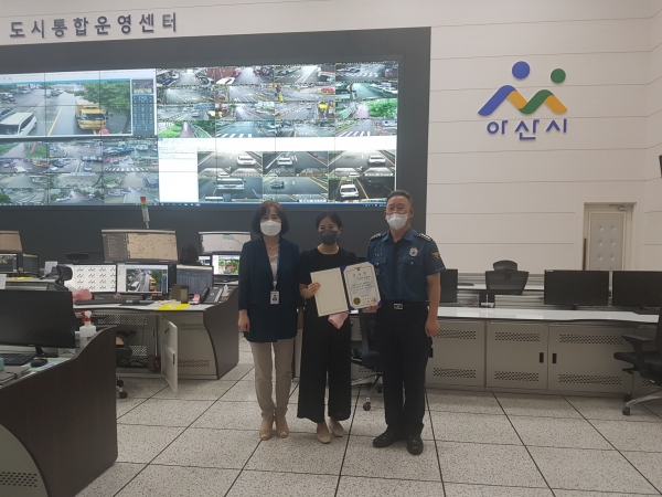 아산시 CCTV통합관제센터 관제요원이 감사장을 받고 기념사진을 찍고 있다