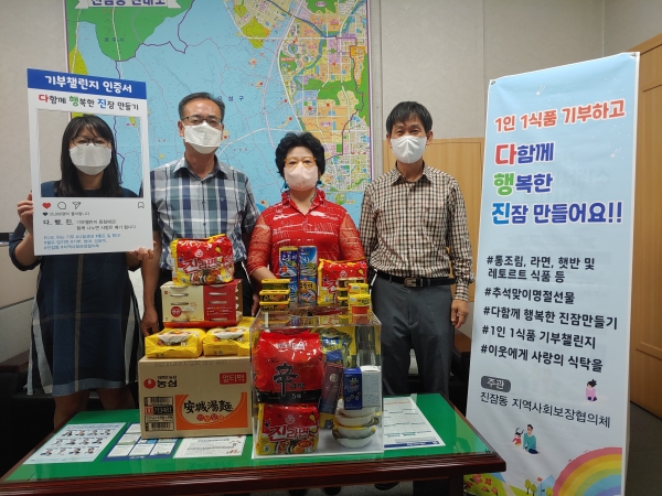 김용숙 진잠동 지역사회보장협의체 위원장(왼쪽에서 세 번째)이 1인 1식품 기부챌린지 참여해 식품을 기부하고 김용호 진잠동장(왼쪽에서 두 번째)과 기념촬영