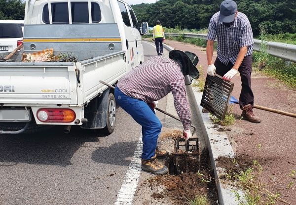 도로보수원이 성연면 왕정리에 위치한 우수받이 우수로를 정비하는 모습