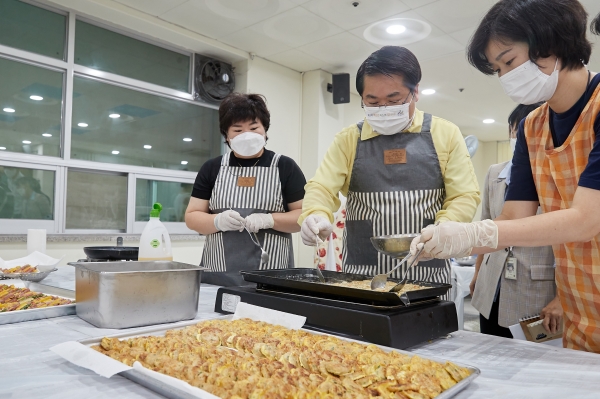 어르신 생활지원사와 함께 전을 부치고 있는 장면