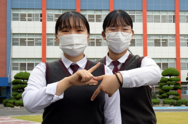 한국전력공사에 최종합격한 대전여상 3학년에 재학 중인 최예리, 지민영 학생이 한전의 ‘전기’를 상징하는 모양을 만들어 포즈를 취하고 있다.