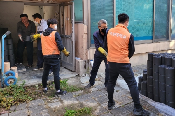 지난 6일 대전 서구 가수원동의 한 마을에서 목원대 교직원으로 구성된 ‘사랑나누기 봉사동아리’와 학생회 회장단 등이 독거노인 가구에 연탄을 나르고 있다.