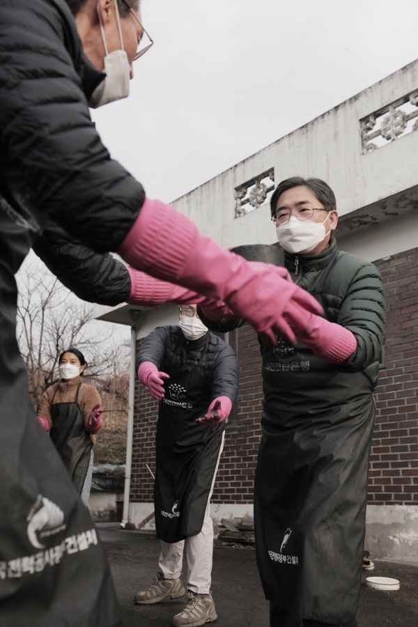 ‘사랑의 연탄 나눔 행사’ 개최 김하용 원장(우)이 교직원들과 연탄을 나르고 있다.